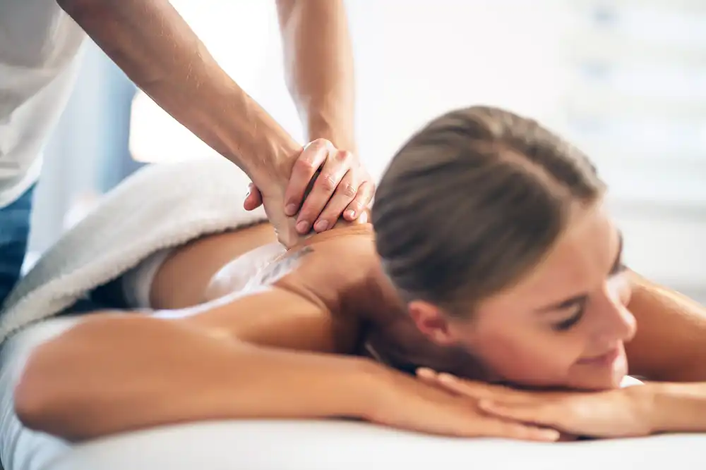 Massage therapist applying pressure to back